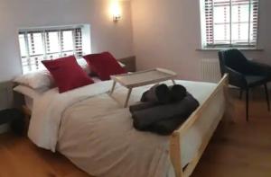 a bedroom with a large white bed with red pillows at Sparks - Turnbridge Guest House in Burnley