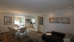 ein Wohnzimmer mit einem Tisch und ein Esszimmer in der Unterkunft Landhaus Strandhafer HT 1 in Wenningstedt-Braderup