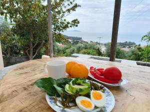 due piatti di uova e verdure su un tavolo di legno di Kitrino Spiti Best View Eco Villa a Patitiri