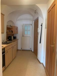 a kitchen with wooden cabinets and a window at City Center Golden Roof 4 in Innsbruck +3 photos