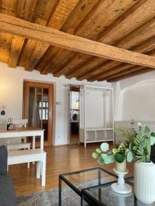 a living room with wooden ceilings and a glass table at City Center Golden Roof 4 in Innsbruck