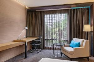 a hotel room with a desk and a chair at Four Points by Sheraton Bangkok, Sukhumvit 15 in Bangkok