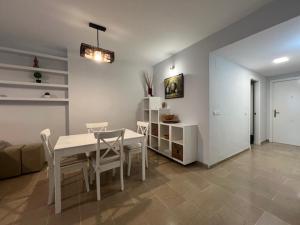a dining room with a white table and chairs at Puerto Marina in Benalmádena +10 photos