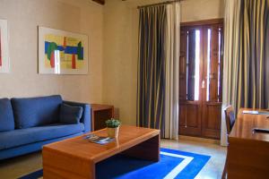 a living room with a blue couch and a coffee table at Sercotel Palacio de Tudemir in Orihuela