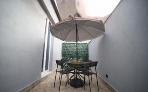 a table and chairs with an umbrella in a room at La casa di Penelope in Catania