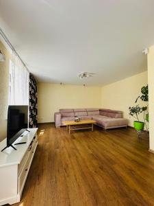 a living room with a couch and a table at Rožu namu apartamenti in Kuldīga