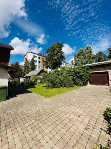 a brick driveway with a building in the background at Rožu namu apartamenti in Kuldīga