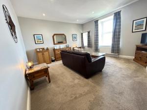 a living room with a couch and a table at Chandlers BnB in Seahouses