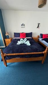 a bedroom with a wooden bed with a blue comforter at Puffin rooms in Lisdoonvarna