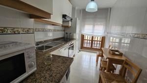 a kitchen with a table and a counter top at Apartamento Cuevas de Mar in Cuevas +15 photos