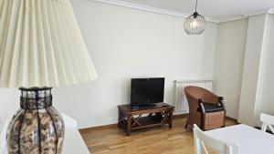 a living room with a tv and a table at Apartamento Cuevas de Mar in Cuevas