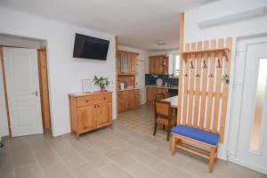 a kitchen with a table and a tv on the wall at Tulipán Vendégház in Polány