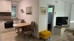 a kitchen with a dining room table and a television at Apartment Malija Cikloped in Izola