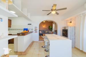 a kitchen with white walls and a ceiling fan at Casa Horizonte in Moraira