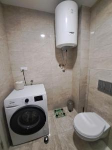 a bathroom with a washing machine and a toilet at Plavi Paun Apartman in Belgrade +12 photos