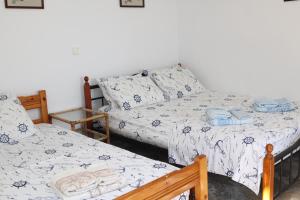 a bedroom with two beds with blue and white sheets at Δωμάτια Κόκκινος Πύργος in Plomarion