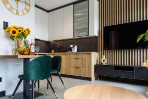 a kitchen with a table and a green chair at Rio - Apartament Plaza Tower - Targi Kielce - Faktura VAT- INVOICE - Air Condition in Kielce