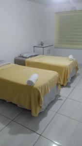 twee bedden in een kamer met gele lakens erop bij 17 driffield road in East London