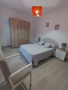 a bedroom with a bed and a chair in it at Apartamento Lago Pereira in Muxia