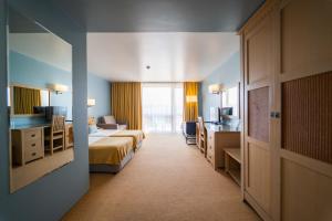 a hotel room with two beds and a desk at HVD Clubhotel Miramar - 24 Hours Ultra All Inclusive & Free Parking in Obzor +95 photos