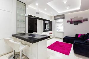 ソポトにあるWhite Apartmentのキッチン、リビングルーム(黒いカウンター、ピンクのラグ付)