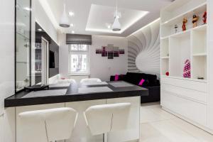 ソポトにあるWhite Apartmentの白いキッチン(黒いカウンター、白い椅子付) +9枚の写真