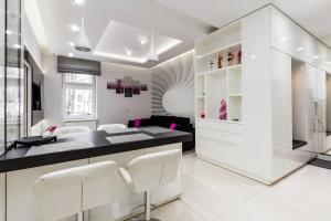 ソポトにあるWhite Apartmentの白い壁のキッチン、カウンター(白い椅子付)