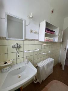 a bathroom with a sink and a mirror and a radiator at apartman pro 4 osoby in Česká Skalice +47 photos