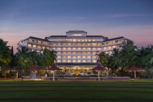 a lit up hotel with palm trees in front of it at Le Meridien Kochi in Cochin