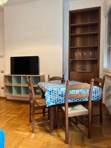 a dining room with a table and chairs and a television at Suite D'Annunzio in Ravenna