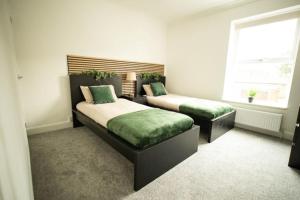 a bedroom with two beds and a window at Spacious - Sleeps 5 - Garden - Close To Sea in Gorleston-on-Sea