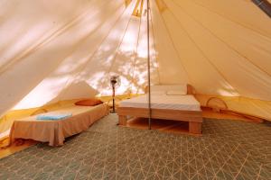 a tent with two beds and a table in it at Burano Camping Beach-Bar in Néa Thésis