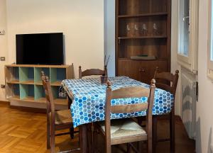 a dining room with a table and a television at Suite D'Annunzio in Ravenna