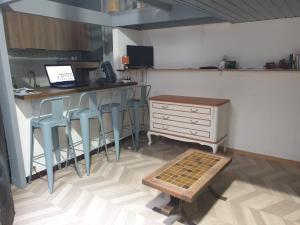 a kitchen with a bar with stools and a desk with a laptop at Grand Studio Centre de Cambrai in Cambrai