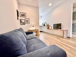 a living room with a blue couch and a tv at Charming retreat off the sea front in Il-Gżira