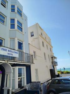 a tall white building with a hotel sign on it at The Willows in Brighton & Hove