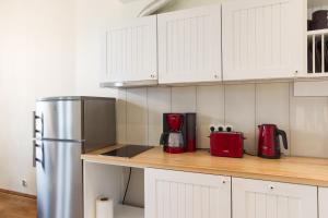 a kitchen with white cabinets and a stainless steel refrigerator at Rebeca külaliskorter in Haapsalu