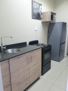 Una cocina con fregadero, estufa y refrigerador. en Bayside Hotel Self Catering Apartments, en Durban 18 fotos más
