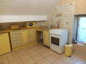 a kitchen with yellow cabinets and a sink and a stove at Karine Boucau 1er étage in Boucau
