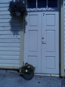a garage with a door and a potted plant at Rebeca külaliskorter in Haapsalu