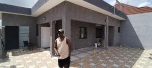 a man standing in front of a house at Immeuble do-rego in Akwen