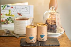 a table with three cups of coffee and a glass jar at Church Farm B&B Suffolk in Great Welnetham +24 photos