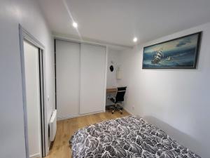 a bedroom with a bed and a desk in it at Nassima in Malesherbes