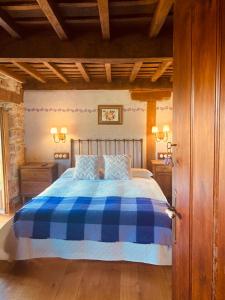 a bedroom with a bed with a blue and white plaid blanket at Posada la Trebede in Perrozo