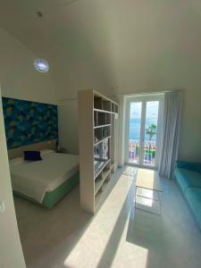 una camera da letto con un letto, un divano e una finestra di La Camera della Nonna 2.0 a Gaeta