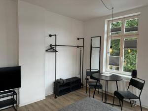 a living room with a table and chairs and a tv at Apartmenthaus Buxtehude St -Petri-Platz Apt 2 in Buxtehude
