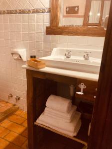 a bathroom with a sink and a pile of towels at Posada la Trebede in Perrozo +51 photos