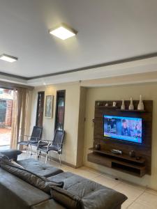 a living room with a couch and a flat screen tv at Oga Guasu casa con piscina exclusiva in Puerto Iguazú