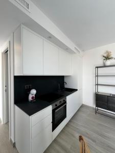 a kitchen with white cabinets and a black counter top at Loft Huerto Old Town in Estepona