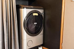 a washer and dryer sitting next to a curtain at Holiday cottage BEPPU ICHIYA in Beppu
